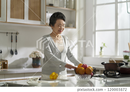 asian elderly woman standing in modern kitchen at home 120003872