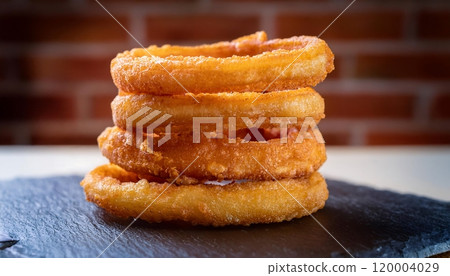 Golden brown crispy fried onions are a popular appetizer in many restaurants. Golden brown crispy fried onions are a popular appetizer in many restaurants. 120004029