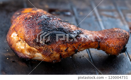 a grilled chicken leg with dark char marks a grilled chicken leg with dark char marks 120004731