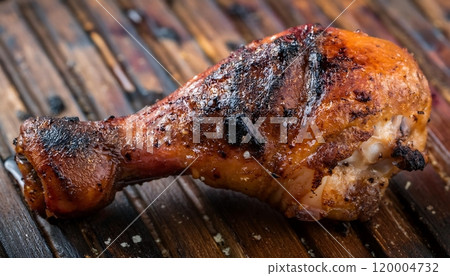a grilled chicken leg with dark char marks a grilled chicken leg with dark char marks 120004732