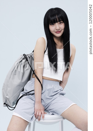 Korean Woman in Her 20s Poses Sitting on Chair in Block Core fashion 120005042