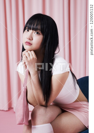A Korean Woman in Her 20s Poses on a Chair in a Barbie Core fashion 120005132