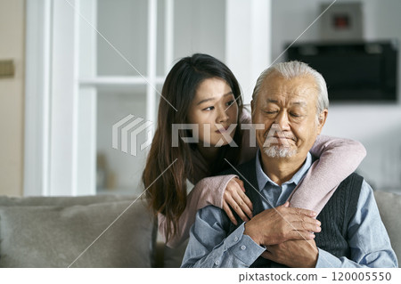 young asian adult daughter conforting senior father at home 120005550