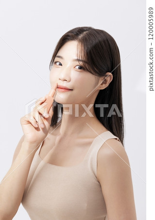 a woman holding a lipstick in the sun a woman holding a lipstick in the sun 120005989