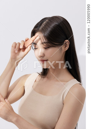 a woman holding a lipstick in the sun 120005990