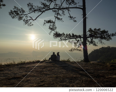 Loei Province, Thailand  27 June 2022, couple traveler sitting for watch sun rise at Nok Aen Cliff Phu Kradueng 120006522