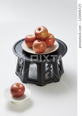 A pile of apples placed on a plate above and below the refreshment table. 120006725