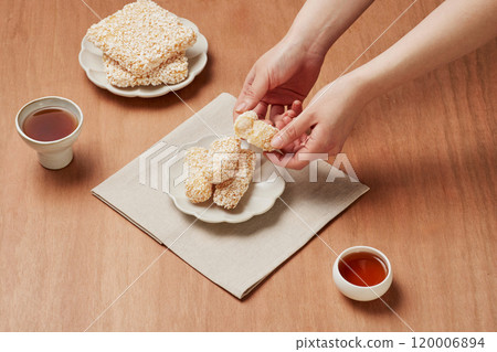A woman cutting a large bowl of Korean sweets in half 120006894