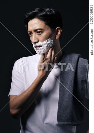 Middleaged man applying shaving cream to his face with one hand 120006922