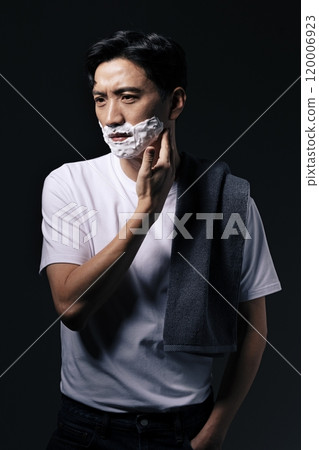 Middleaged man applying shaving cream to his face with one hand Middleaged man applying shaving cream to his face with one hand 120006923