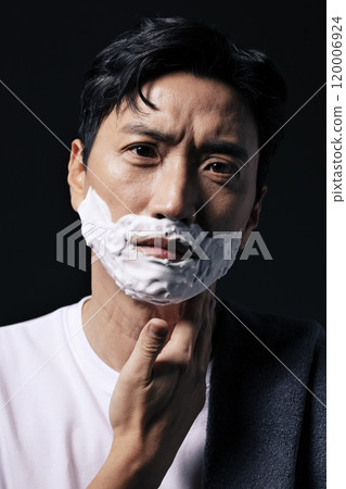 Middleaged man applying shaving cream to his face with one hand Middleaged man applying shaving cream to his face with one hand 120006924