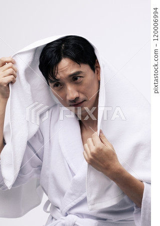 A middleaged man wearing a white towel on his head A middleaged man wearing a white towel on his head 120006994