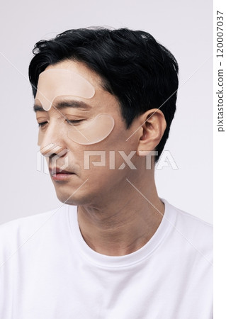 Middleaged man with cosmetic patches on his face Middleaged man with cosmetic patches on his face 120007037
