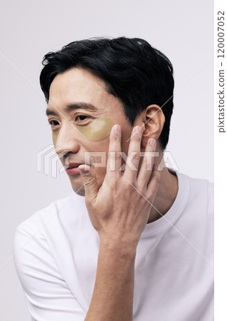 A middleaged man smiling with an eye patch around his eyes 120007052