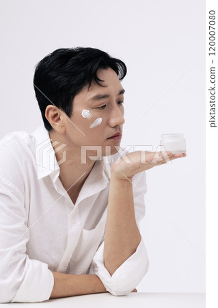 A middleaged man holding a can of cream in his palm 120007080