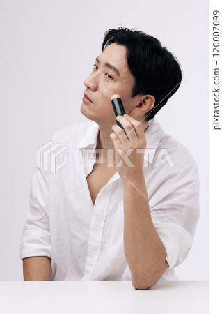 Middleaged man applying foundation to his face 120007099