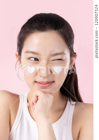 A teenage woman with a sticker on her face and a cute expression on her face 120007324