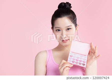 A teenage woman posing with an eyeshadow palette A teenage woman posing with an eyeshadow palette 120007424