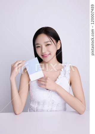 A woman in her 20s posing with a personal color drape swatch. A woman in her 20s posing with a personal color drape swatch. 120007489