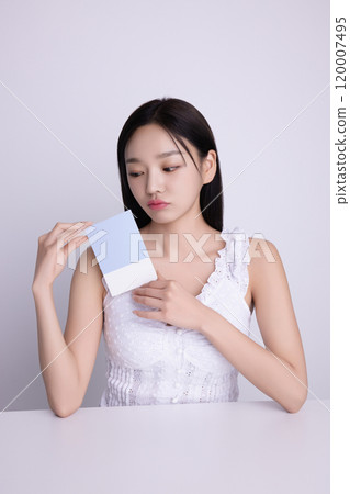 A woman in her 20s posing with a personal color drape swatch. A woman in her 20s posing with a personal color drape swatch. 120007495