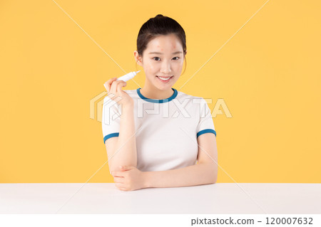 Teenage woman using skincare products to remove skin problems on her face 120007632