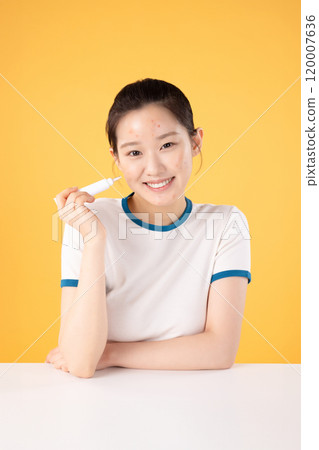 Teenage woman using skincare products to remove skin problems on her face 120007636
