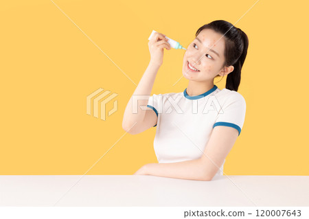 Teenage woman using skincare products to remove skin problems on her face 120007643