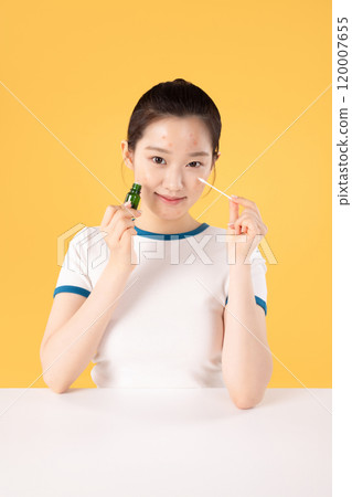 Teenage woman using skincare products to remove skin problems on her face 120007655