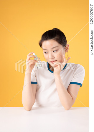 Teenage woman using skincare products to remove skin problems on her face Teenage woman using skincare products to remove skin problems on her face 120007667