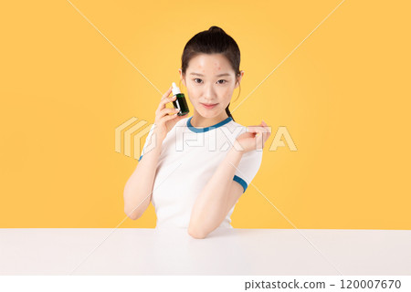 Teenage woman using skincare products to remove skin problems on her face Teenage woman using skincare products to remove skin problems on her face 120007670