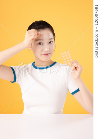 Teenage woman using skincare products to remove skin problems on her face 120007691