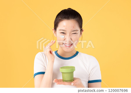 Teenage woman using skincare products to remove skin problems on her face 120007696