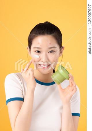 Teenage woman using skincare products to remove skin problems on her face 120007697