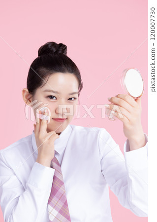 A teenage woman wearing a school uniform and holding cosmetics in a cute pose 120007730