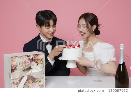Newlywed couple smiling happily holding wedding cake 120007952
