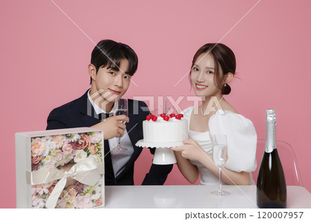Newlywed couple smiling happily holding wedding cake 120007957