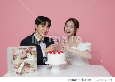 Newlywed couple smiling happily holding wedding cake 120007973