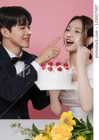Newlywed couple smiling happily holding wedding cake 120007987