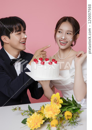 Newlywed couple smiling happily holding wedding cake Newlywed couple smiling happily holding wedding cake 120007988
