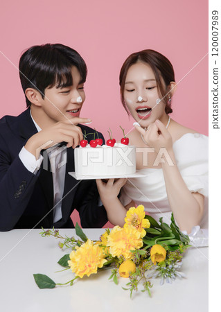Newlywed couple smiling happily holding wedding cake Newlywed couple smiling happily holding wedding cake 120007989
