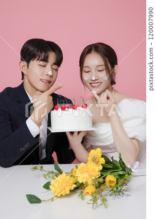 Newlywed couple smiling happily holding wedding cake Newlywed couple smiling happily holding wedding cake 120007990