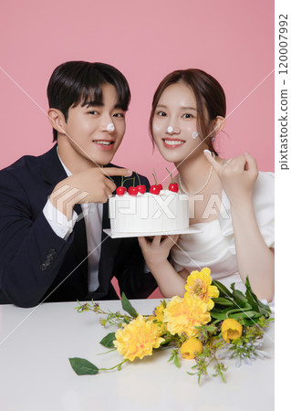 Newlywed couple smiling happily holding wedding cake Newlywed couple smiling happily holding wedding cake 120007992