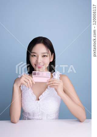 A woman in her 20s posing with a cool-toned color shadow palette A woman in her 20s posing with a cool-toned color shadow palette 120008117