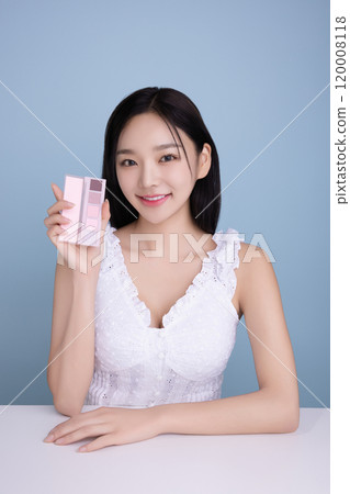 A woman in her 20s posing with a cool-toned color shadow palette 120008118