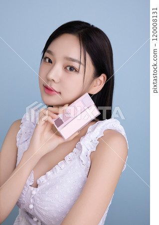 A woman in her 20s posing with a cool-toned color shadow palette 120008131