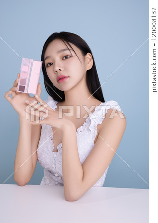 A woman in her 20s posing with a cool-toned color shadow palette 120008132