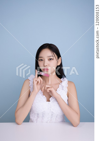 A woman in her 20s posing with a cool-toned lip product A woman in her 20s posing with a cool-toned lip product 120008153