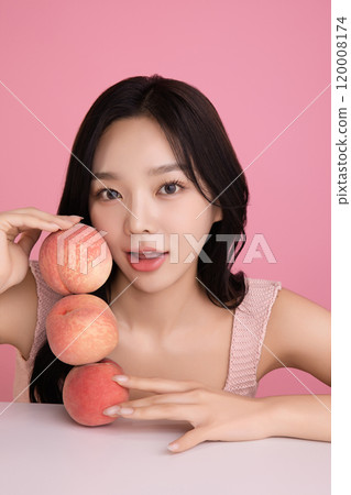 A woman in her 20s posing with a peach on the table 120008174