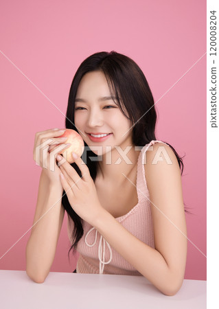 A woman in her 20s holding a peach and holding various poses A woman in her 20s holding a peach and holding various poses 120008204