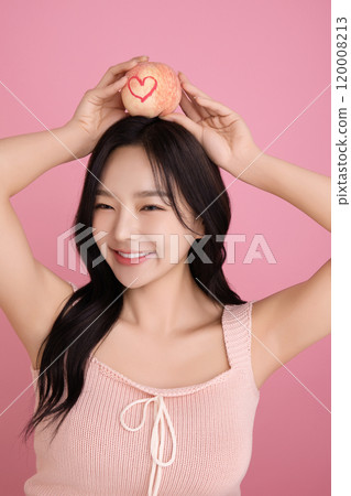 A woman in her 20s holding a peach and holding various poses A woman in her 20s holding a peach and holding various poses 120008213
